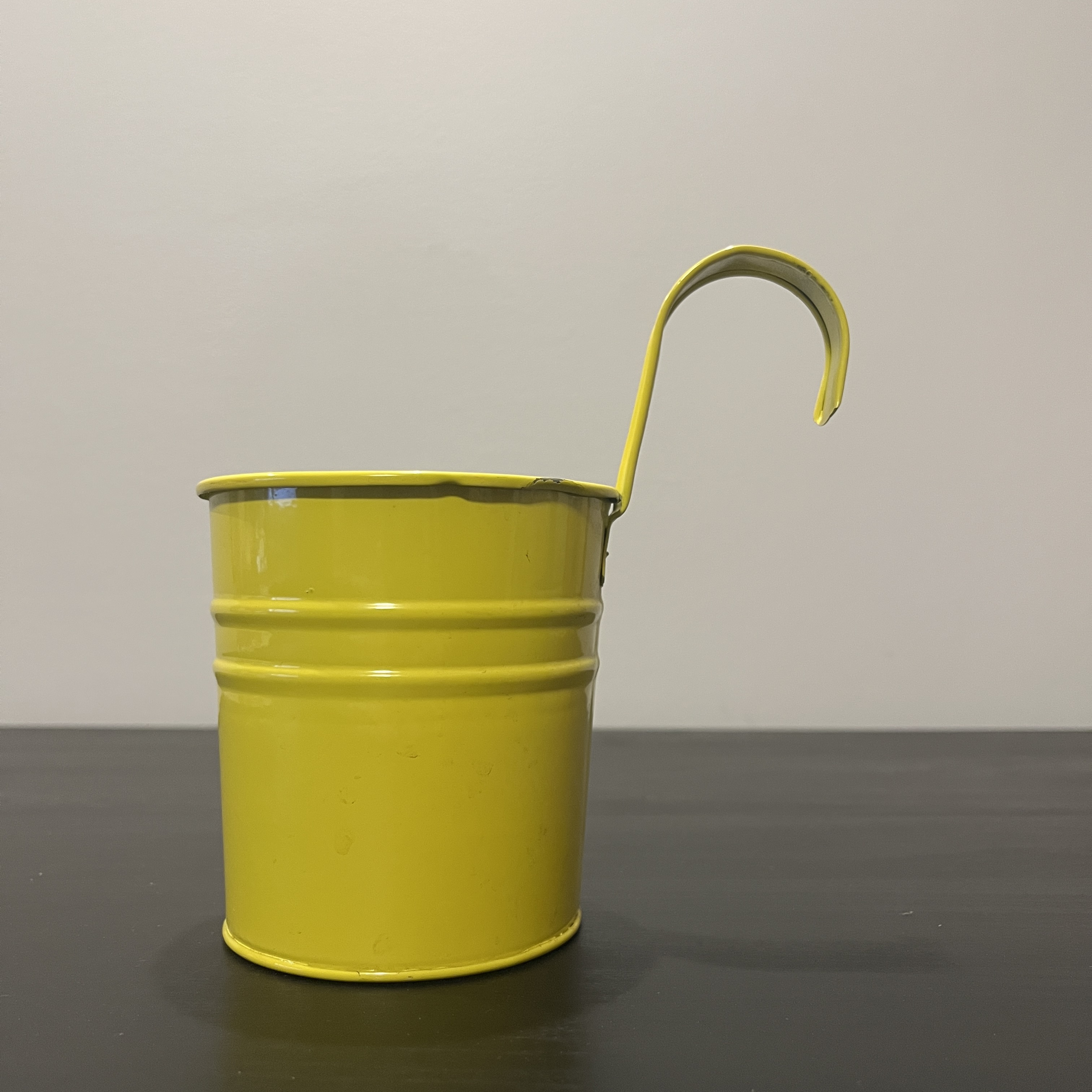 A painted-metal hanging gardening pot.